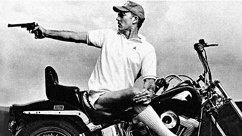 Hunter S. Thompson on motorbike with revolver